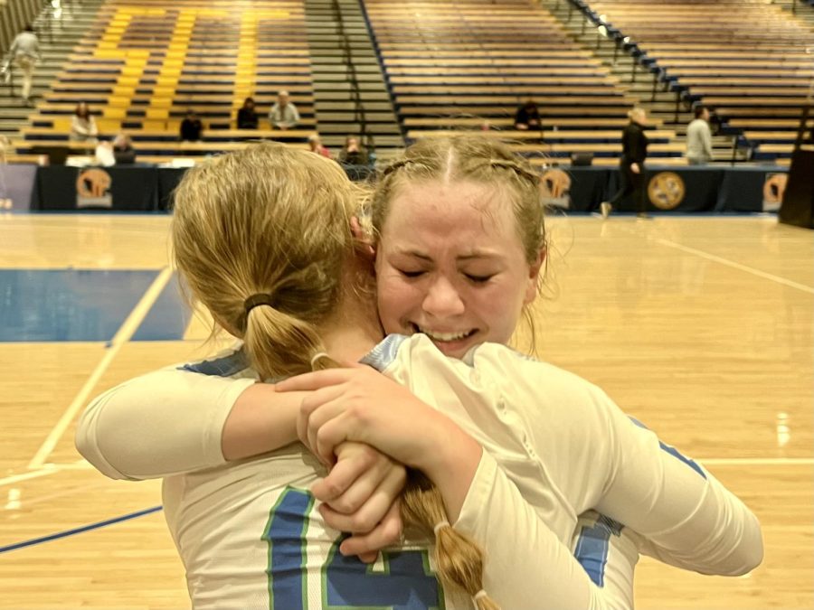 Dylan Whisenant, who won a game award, hugs Celia Tolmie (14) after girls varsity volleyball won the Division I state championship, Nov. 18, 2022. The five-set title game, held in Orange County, concluded a historic season for the team.