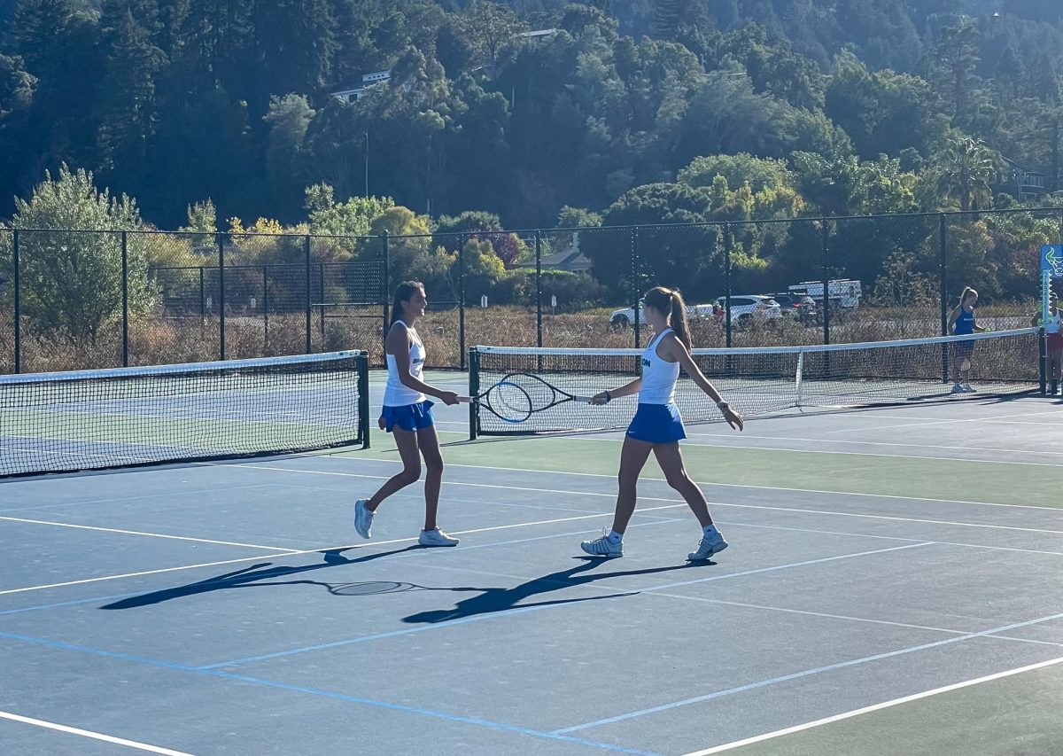 Tara Sridharan and Laila Elkhoury bump rackets on the court. The duo lost the match with scores of 4-6, 0-6.