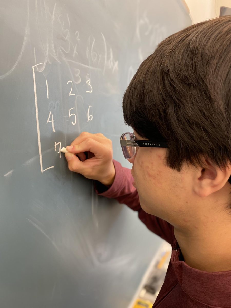 Owen Xu 25 solves a math problem in Bransons Linear Algebra course. The class has transitioned to the new problem-based curriculum under the leadership of Gayatri Ramesh, the Chair of the Math Department.