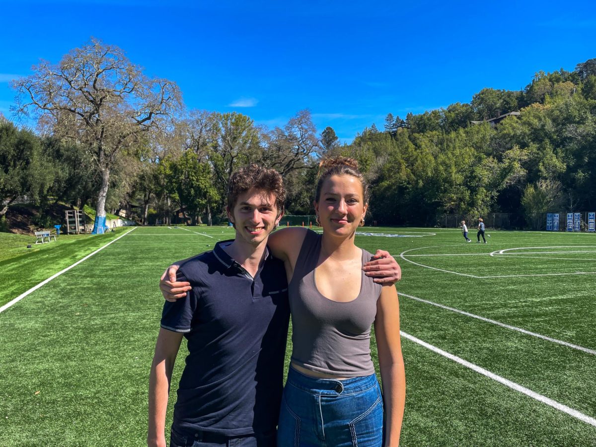 Alexander LaMonica ‘24 and Sabine Fuchs ‘25, awardees of the Impact App Challenge, stand together on Tom Ryan Field. They developed Nectar Connect, an app set to be published later this year.