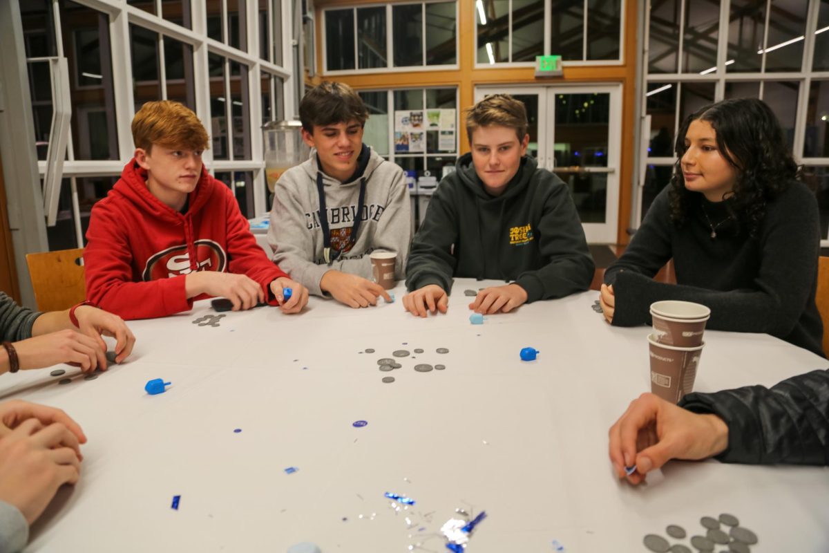 Students gather around a table during the Jew Crews Hanukkah celebration at Branson on December 10. The celebration included playing dreidel, a traditional Hanukkah game, as part of the festivities organized by the Jew Crew Affinity.
