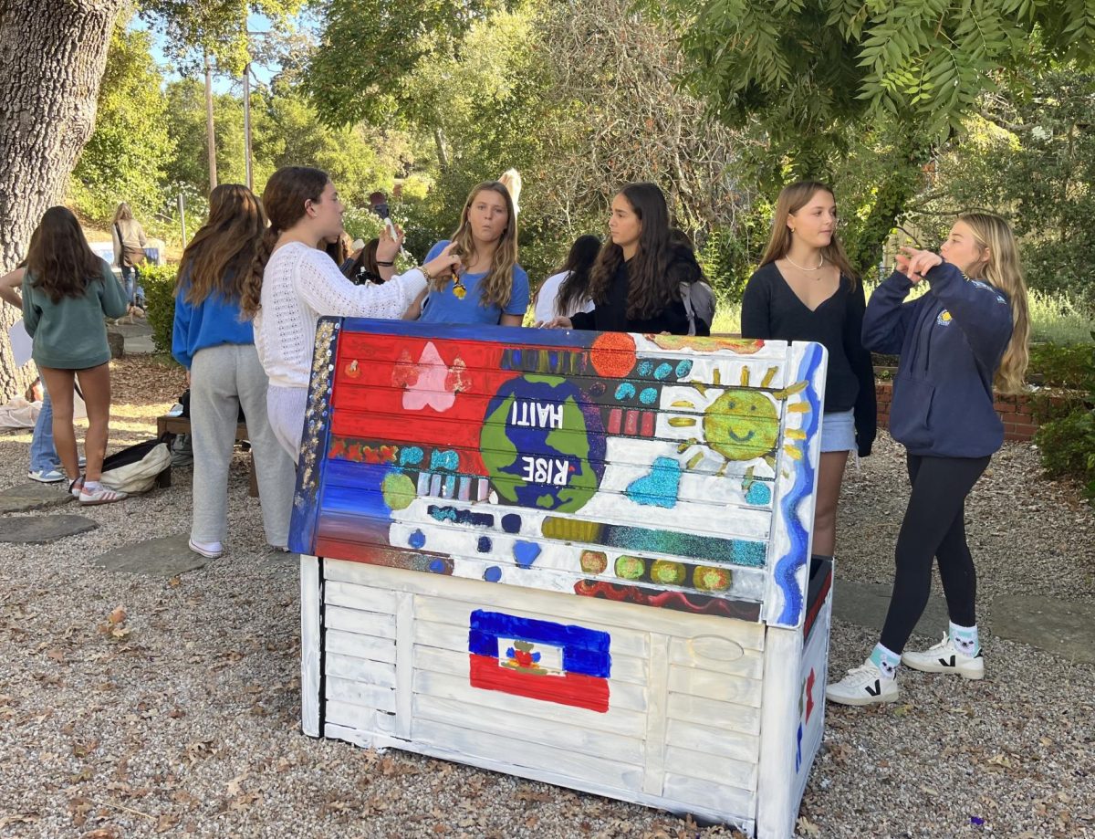 Rise Haiti club members paint clothing donation bin. The new club this year is donating care packages to Changing Tides, an orphanage in Haiti.