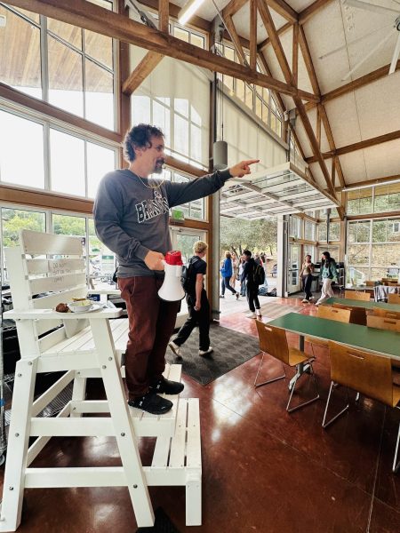 Commons cleanup advocate Jeff Symonds calls out students who fail to clean up during lunch. Symonds and other faculty have taken turns sitting in the newly implemented lifeguard chair to supervise the commons at lunch.